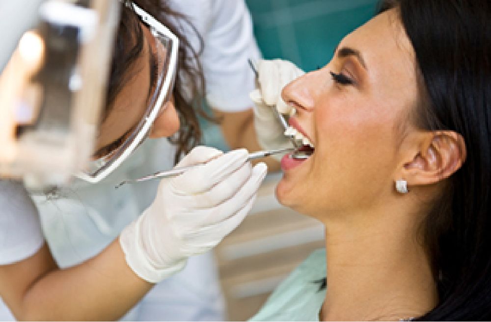 woman getting teeth cleaned professionally